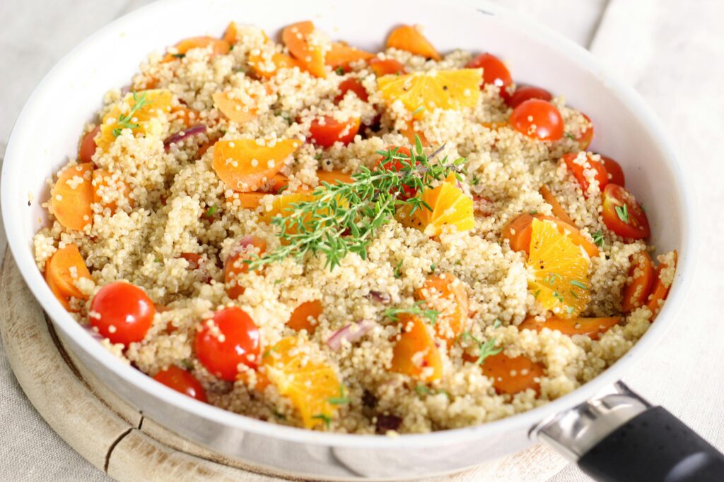 Delicious vegan quinoa salad with tomatoes, oranges, and fresh herbs.