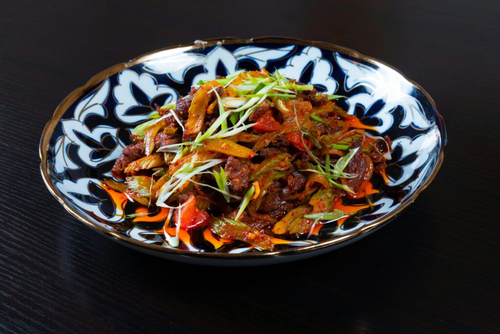 Delicious stir-fried meat and vegetables served hot on a decorative plate.