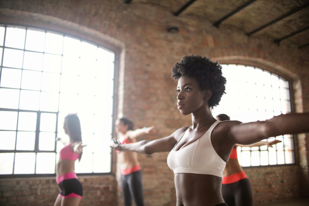 Diverse group of people exercising in an industrial-style loft with brick walls.