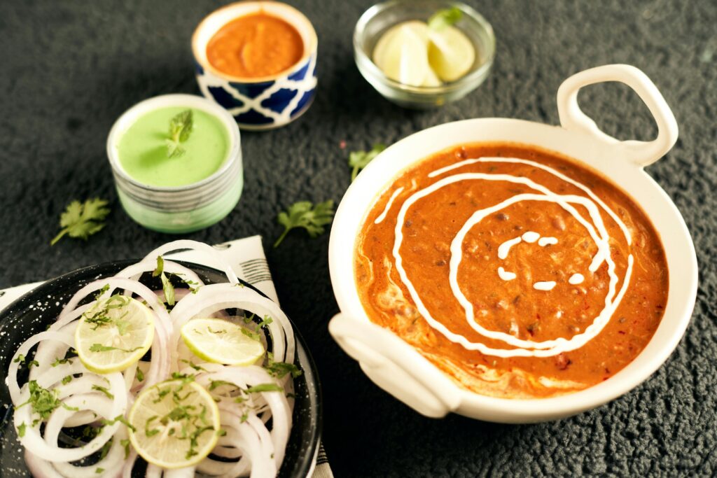 Close-up of homemade dal makhani served with lemon and onion garnish.