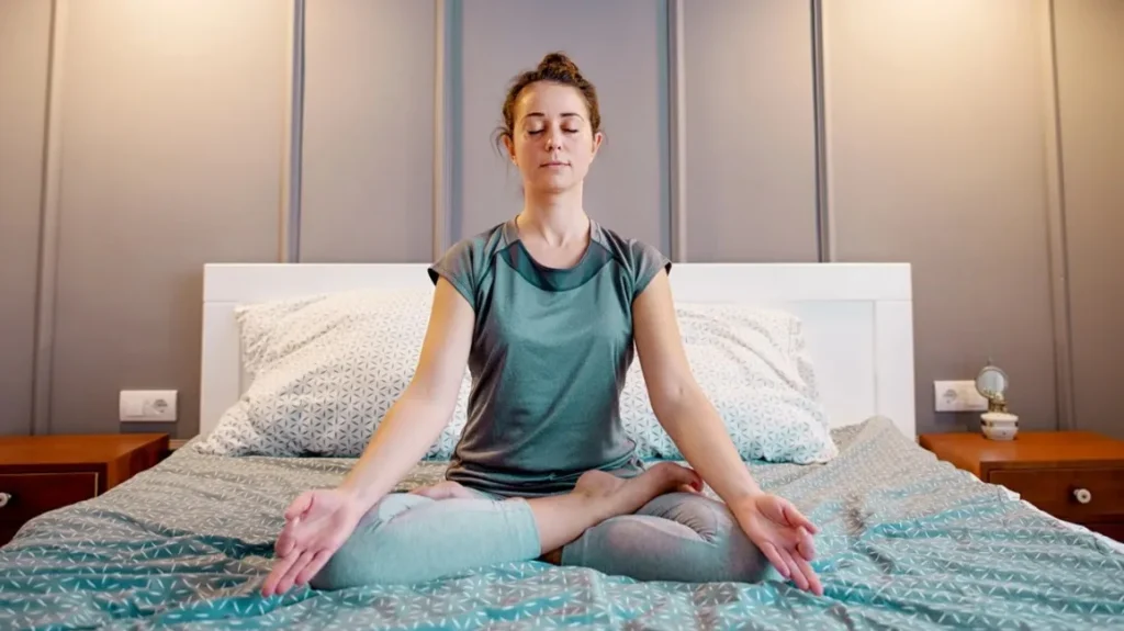 woman practising yoga on the bed